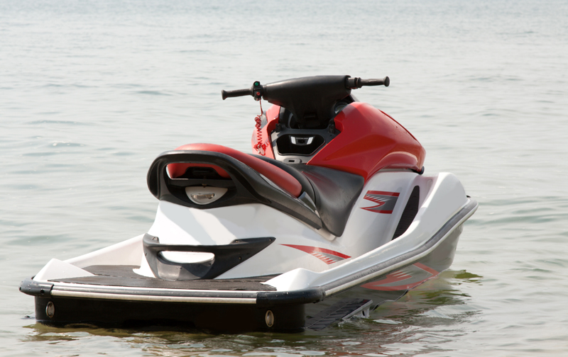 Photo of a red and white jet ski on water with no person on it
